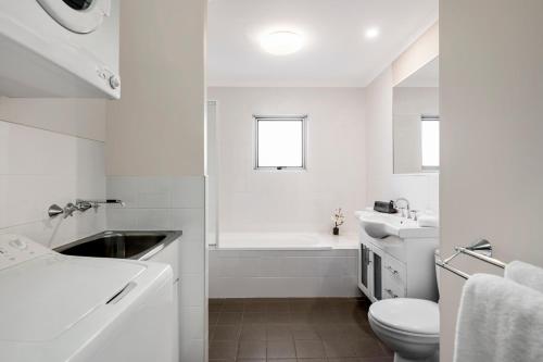 a bathroom with a sink, toilet and bathtub at Quest Wollongong in Wollongong
