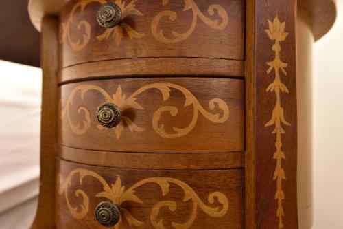 a wooden dresser with gold designs on it at Casa Culinaria - The Gourmet Inn in Santa Fe
