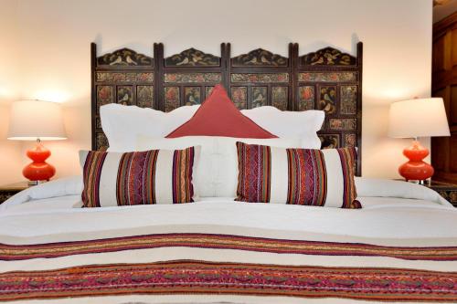 a bedroom with a large white bed with red pillows at Casa Culinaria - The Gourmet Inn in Santa Fe