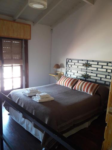 a bedroom with a large bed with towels on it at Apart Piedra Libre in Tandil