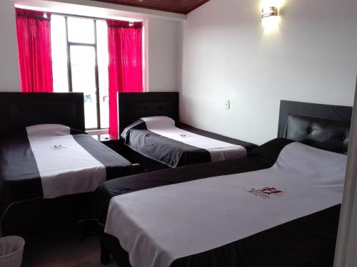 パイパにあるHotel Hortensia Realの赤いカーテン付きの部屋のベッド3台
