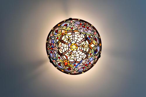 a stained glass egg light fixture on a wall at Casa Culinaria - The Gourmet Inn in Santa Fe
