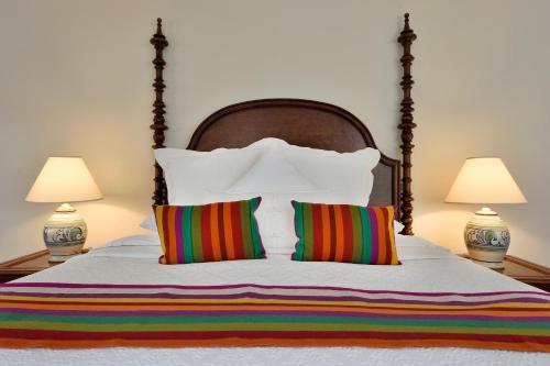 a bed with two lamps and two striped pillows at Casa Culinaria - The Gourmet Inn in Santa Fe