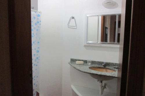 y baño con lavabo y espejo. en Corsário, en Florianópolis