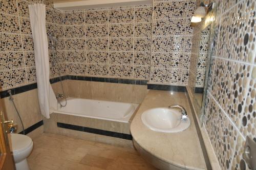 Un baño con lavabo, bañera e inodoro. en Babylon Appartments, en Marrakech