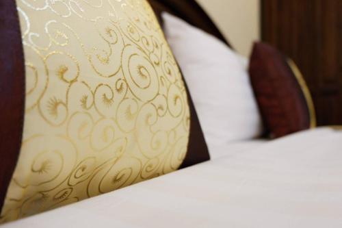 a bed with a pillow with a pattern on it at NanBaanKhun Hotel in Nan