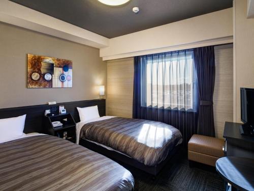 מיטה או מיטות בחדר ב-Hotel Route-Inn Ishioka