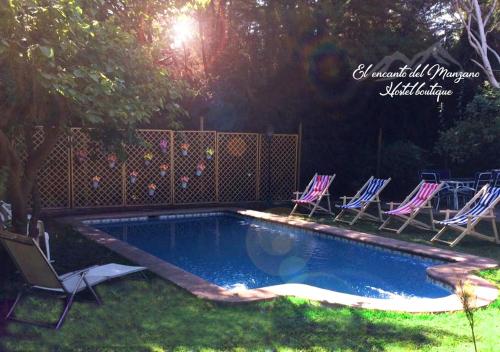 a swimming pool with chairs in a yard at El Encanto del Manzano & Espacio Vittalia Spa in San José de Maipo