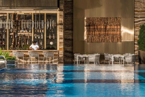 een hotellobby met een zwembad en een restaurant bij Four Seasons Hotel Kuala Lumpur in Kuala Lumpur