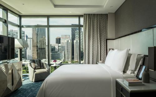a hotel room with a bed and a large window at Four Seasons Hotel Kuala Lumpur in Kuala Lumpur