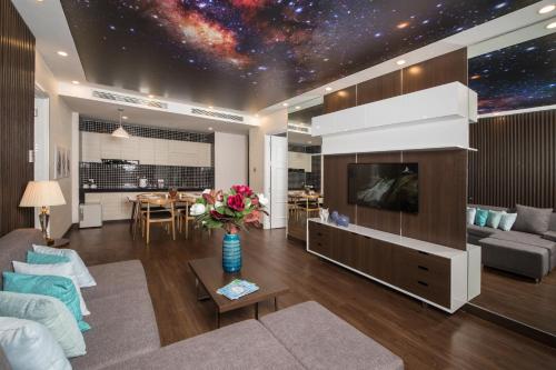 a living room with a couch and a tv with a galaxy mural at HAIAN Beach Hotel & Spa in Danang