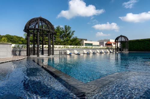a swimming pool with chairs and a gazebo at Grand Park City Hall in Singapore