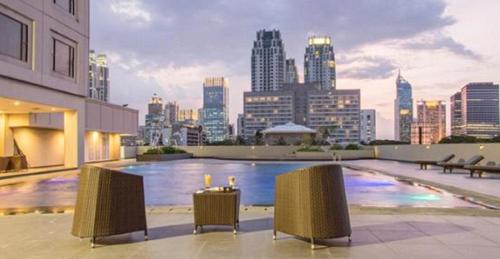 a pool on top of a building with a city skyline at Royal Kuningan in Jakarta