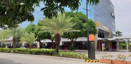 a street with palm trees in front of a building at Mactan Newtown Ocean View 360 Degree in Mactan