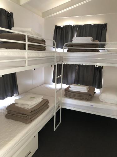 a room with white bunk beds with towels at Geelong Surfcoast Hwy Holiday Park in Mount Duneed