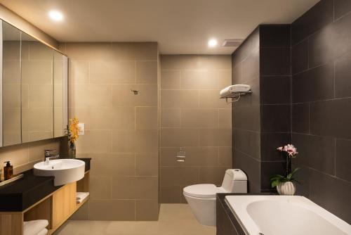 a bathroom with a sink and a toilet and a tub at Citadines Central Binh Duong in Thuan An