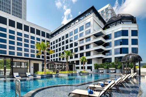a hotel with a swimming pool in front of a building at Grand Park City Hall in Singapore