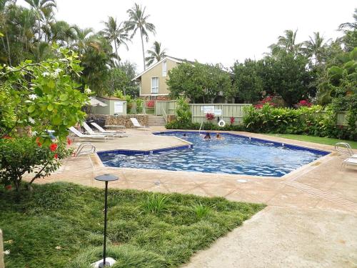 una piscina en un patio con una casa en Elegant Turtle Bay Condo en Kahuku