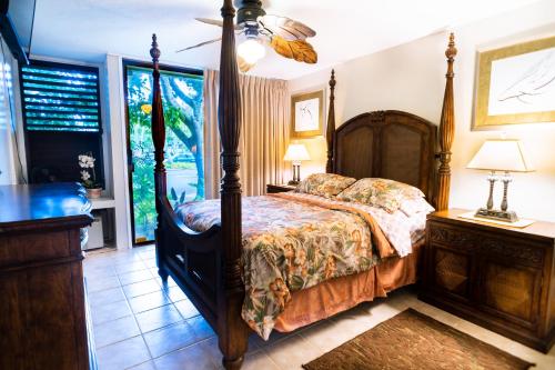 a bedroom with a canopy bed and a window at Elegant Turtle Bay Condo in Kahuku