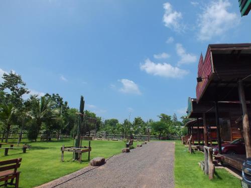 un chemin de terre dans un parc à côté d'un bâtiment dans l'établissement Stonewood Cowboy City Resort, à Ban Krok Duan Ha