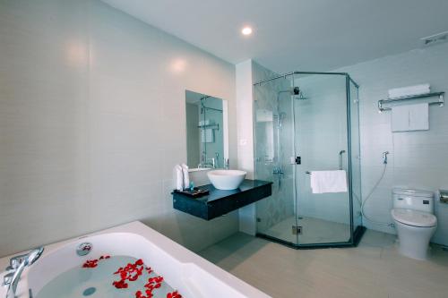 a bathroom with a tub and a sink and a toilet at Sun Bay Tuan Chau Hotel in Ha Long