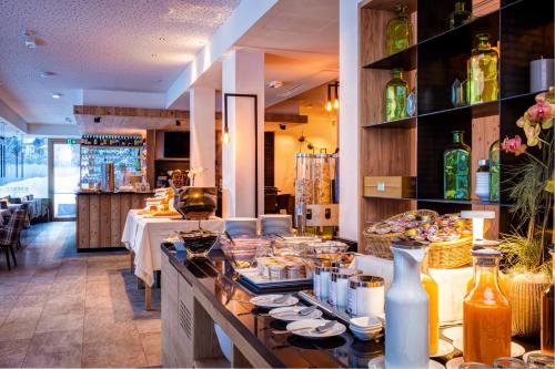 a restaurant with a buffet of food on a counter at Mountain Design Hotel EdenSelva in Selva di Val Gardena