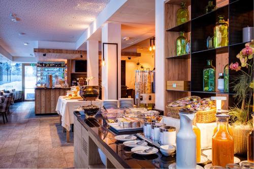 ein Restaurant mit einem Buffet an der Theke in der Unterkunft Mountain Design Hotel EdenSelva in Wolkenstein in Gröden