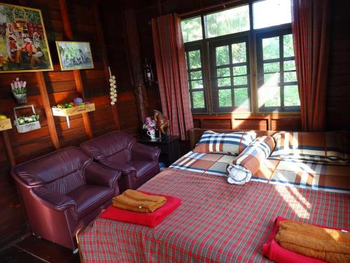 ein Schlafzimmer mit einem Bett und einer Couch in der Unterkunft Stonewood Cowboy City Resort in Ban Krok Duan Ha