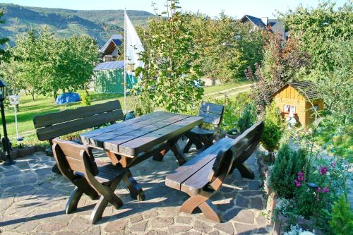 a picnic table and two benches in a garden at Hotel Restaurant Moselblick in Wintrich
