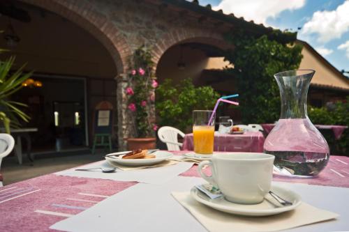 un tavolo con una tazza di caffè e un vaso di Hotel Girifalco a Massa Marittima