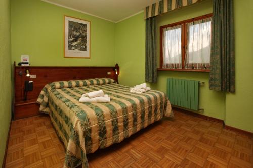 a bedroom with a bed with two towels on it at Assietta in Sauze dʼOulx