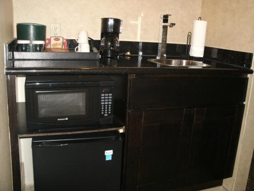 a kitchen counter with a microwave and a sink at Rosedale Inn in Pacific Grove