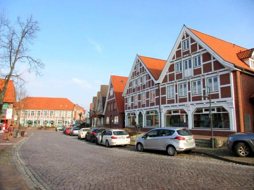 a street with cars parked on the side of a building at Ferienwohnung Altes Land Familie H in Steinkirchen