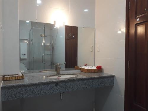 a bathroom with a sink and a large mirror at Laverder Resort in Phú Quốc