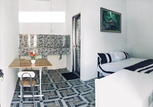 um pequeno quarto com uma cama, uma mesa e uma cama em Gama Apartments em Dili
