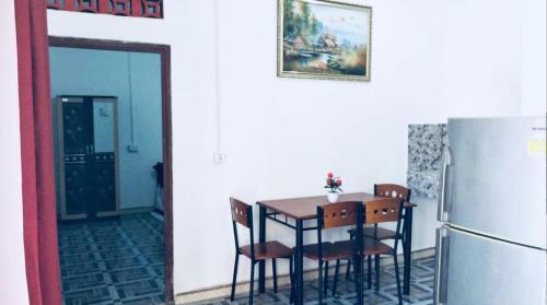uma cozinha com uma mesa com cadeiras e uma geladeira em Gama Apartments em Dili