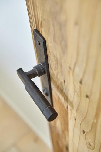 a metal door handle on a wooden door at City Suites Murnau in Murnau am Staffelsee