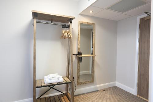 ein Ankleidezimmer mit einem Spiegel und einem Stuhl in der Unterkunft Tulip Queen, Spalding by Marston's Inns in Spalding