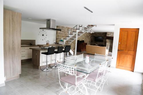 a kitchen and dining room with a glass table and chairs at Maison en Ardeche in Usclades