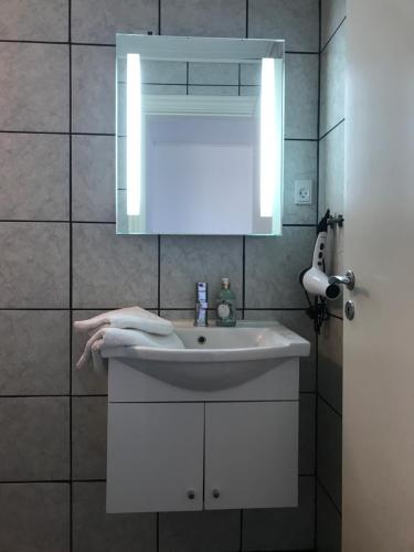 uma casa de banho com um lavatório branco e um espelho. em B&B Apartment Rødekro em Rødekro