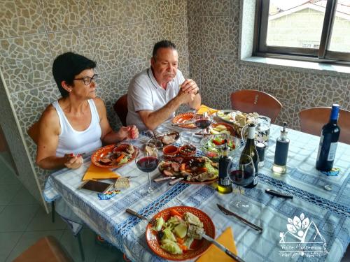 a man and woman sitting at a table with food at Casa Celeste in Castro Daire
