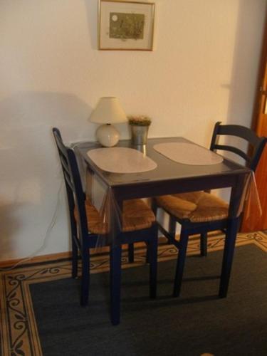 a wooden table with two chairs and a lamp on it at Bebensee Edda DZ in Neustadt in Holstein