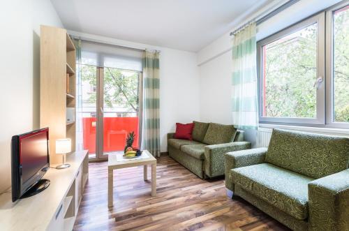 a living room with a couch and a tv at Penzion Palouček in Prague