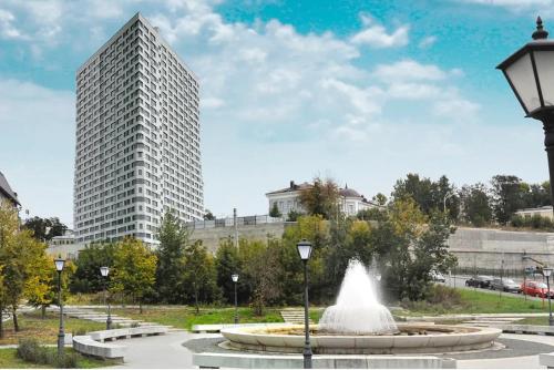 una fuente en un parque con un edificio alto en Skyscraper Apartment en Kazán