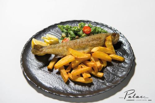 a plate of food with a fish and french fries at Hotel Pałac Jugowice in Wałbrzych