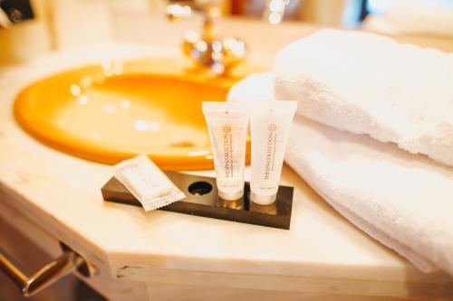 a bathroom sink with two tubes of soap and towels at Meissmers Hotel in Eiterfeld