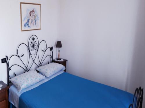 a bedroom with a blue bed with a painting on the wall at B&b Villa C'era Una Volta in Massa