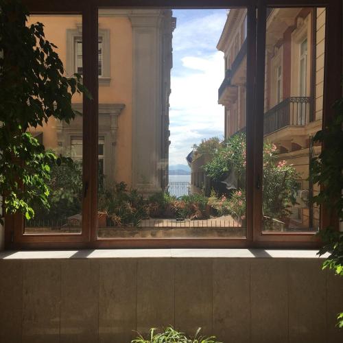 a window with a view of the ocean seen through it at B&B Orsini 46 in Naples