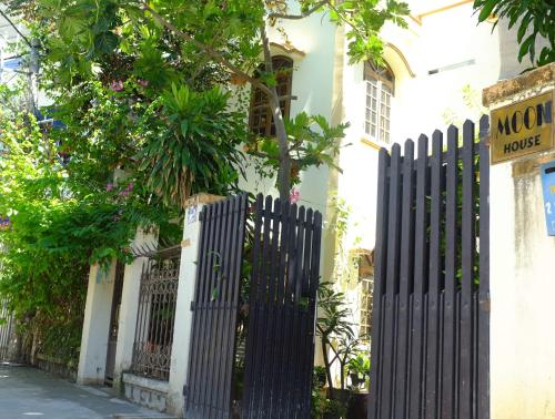 a black fence in front of a white house at Moon house tropical garden - West side in Nha Trang