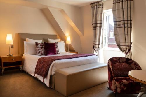 
a hotel room with a bed and a dresser at Hotel & Spa REGENT PETITE FRANCE in Strasbourg
